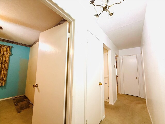 1210 Carroll Dr, Garland, TX 75041 - hallway with light carpet, baseboards, and a chandelier