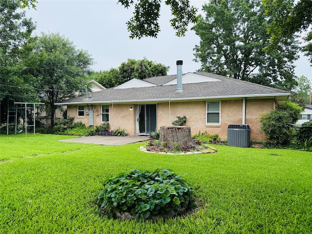1210 Carroll Dr, Garland, TX 75041 - back of house with central air condition unit, a lawn, a shingled roof, and brick siding