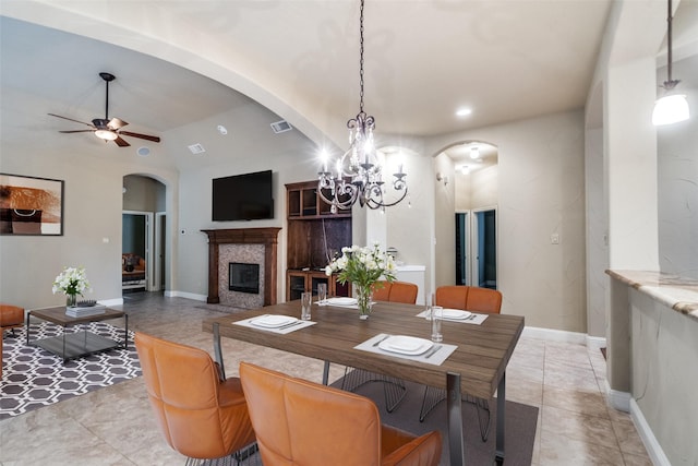 209 Pine Valley Ct, Fairview, TX 75069 - dining space with arched walkways, a ceiling fan, a glass covered fireplace, a chandelier, and vaulted ceiling
