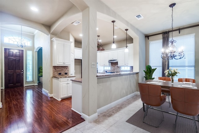 209 Pine Valley Ct, Fairview, TX 75069 - kitchen featuring a chandelier, arched walkways, decorative backsplash, and recessed lighting