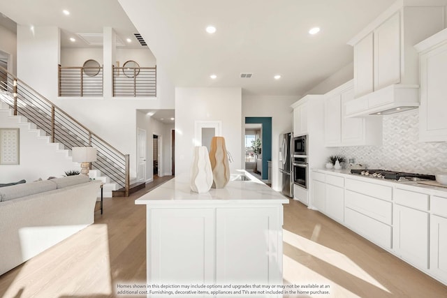 4622 Bel Air Dr, Midlothian, TX 76065 - kitchen with custom exhaust hood, appliances with stainless steel finishes, light wood-type flooring, tasteful backsplash, and open floor plan