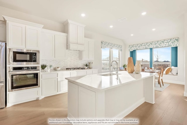 4622 Bel Air Dr, Midlothian, TX 76065 - kitchen featuring appliances with stainless steel finishes, a sink, light wood-type flooring, backsplash, and light countertops
