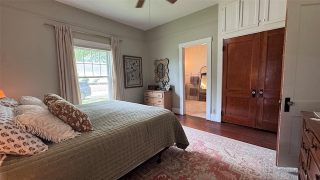 573 S Preston Ave, Van Alstyne, TX 75495 - bedroom with dark wood-style floors, connected bathroom, and a ceiling fan