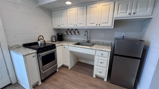 573 S Preston Ave, Van Alstyne, TX 75495 - kitchen with stainless steel appliances, a sink, white cabinetry, and light wood-type flooring
