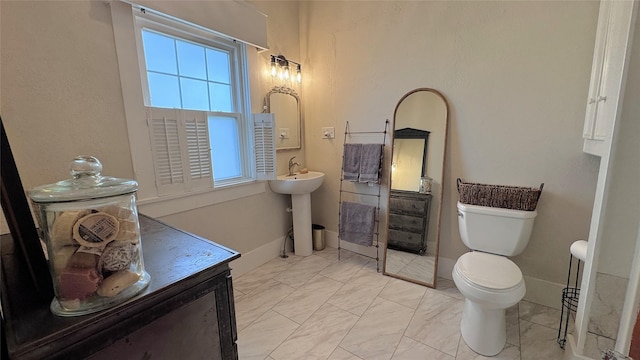 573 S Preston Ave, Van Alstyne, TX 75495 - bathroom with toilet, marble look tiles, and baseboards