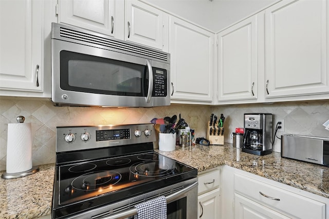 211 Cimarron Trl Unit 8, Irving, TX 75063 - kitchen with appliances with stainless steel finishes, white cabinetry, tasteful backsplash, and light stone countertops