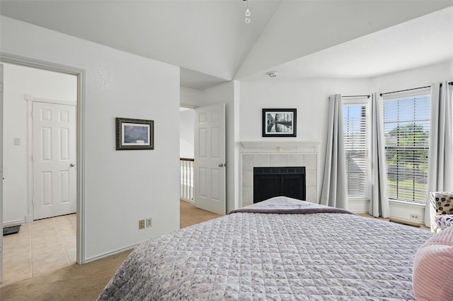 211 Cimarron Trl Unit 8, Irving, TX 75063 - bedroom featuring light colored carpet, vaulted ceiling, baseboards, and a tile fireplace