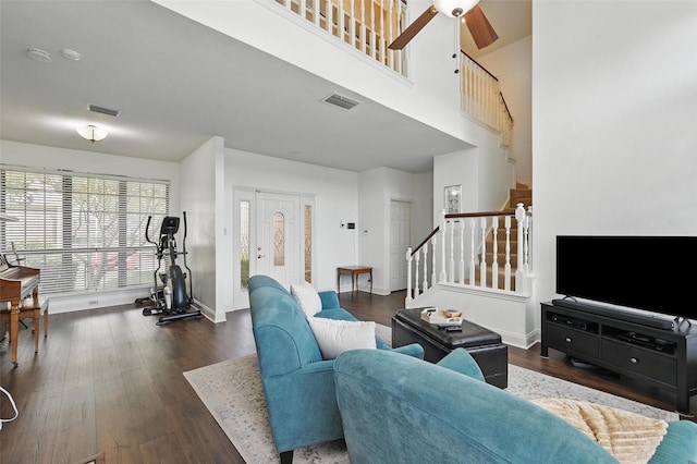 211 Cimarron Trl Unit 8, Irving, TX 75063 - living room featuring stairs, dark wood-style flooring, a ceiling fan, baseboards, and a towering ceiling