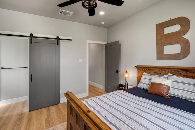 100 Tall Grass Ct, Weatherford, TX 76087 - bedroom with light wood-type flooring, a barn door, baseboards, and ceiling fan
