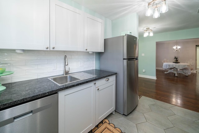 405 Houston St, Sulphur Springs, TX 75482 - kitchen with appliances with stainless steel finishes, a sink, white cabinets, tasteful backsplash, and dark stone counters