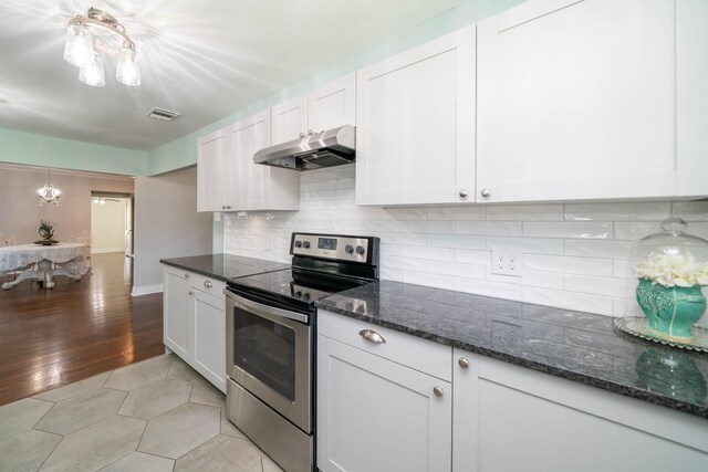405 Houston St, Sulphur Springs, TX 75482 - kitchen featuring stainless steel range with electric cooktop, under cabinet range hood, white cabinetry, decorative backsplash, and dark stone counters