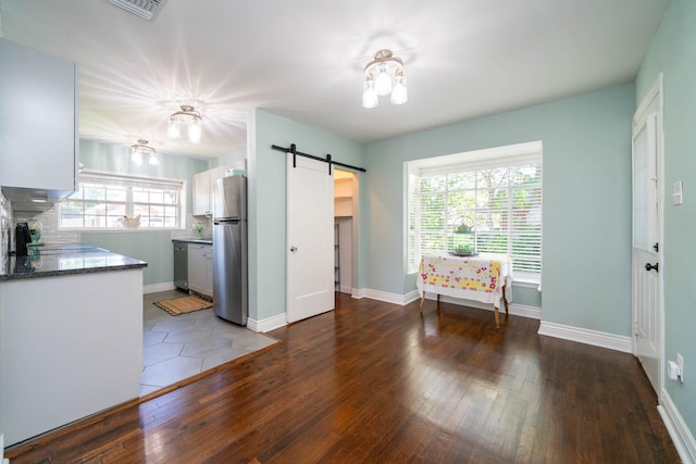 405 Houston St, Sulphur Springs, TX 75482 - kitchen with appliances with stainless steel finishes, a barn door, wood-type flooring, and plenty of natural light