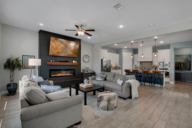 4860 Connor Pl, Fairview, TX 75069 - living room with light wood-style flooring, a fireplace, ceiling fan, recessed lighting, and baseboards
