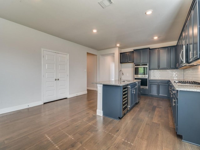 1110 Howley Ct, Forney, TX 75126 - kitchen featuring stainless steel appliances, a sink, light stone counters, backsplash, and a kitchen island with sink