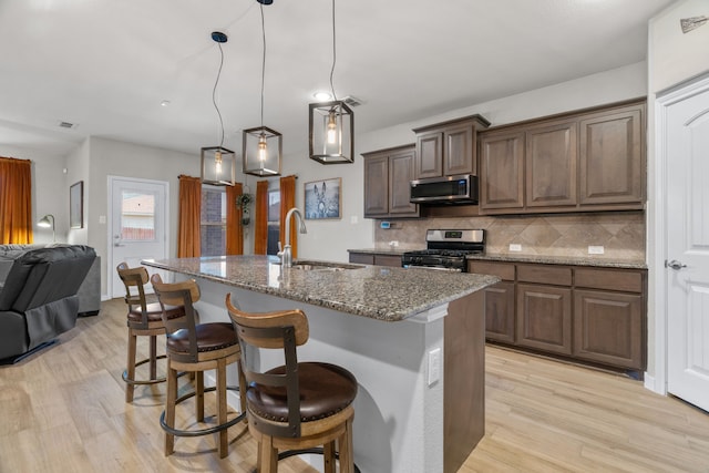 15712 Oak Pointe Dr, Fort Worth, TX 76177 - kitchen with a sink, stainless steel appliances, light wood-type flooring, open floor plan, and tasteful backsplash