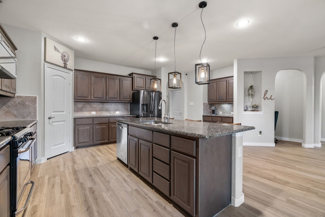 15712 Oak Pointe Dr, Fort Worth, TX 76177 - kitchen featuring stainless steel appliances, arched walkways, backsplash, dark brown cabinets, and recessed lighting