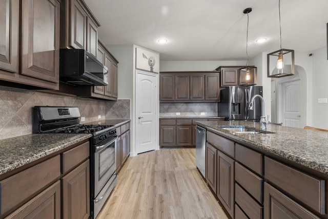 15712 Oak Pointe Dr, Fort Worth, TX 76177 - kitchen featuring appliances with stainless steel finishes, a sink, light wood-style floors, dark stone counters, and recessed lighting