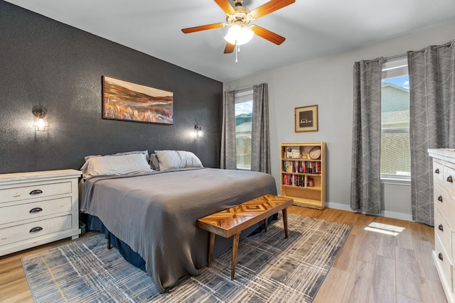 15712 Oak Pointe Dr, Fort Worth, TX 76177 - bedroom featuring light wood-style flooring, a ceiling fan, an accent wall, and baseboards