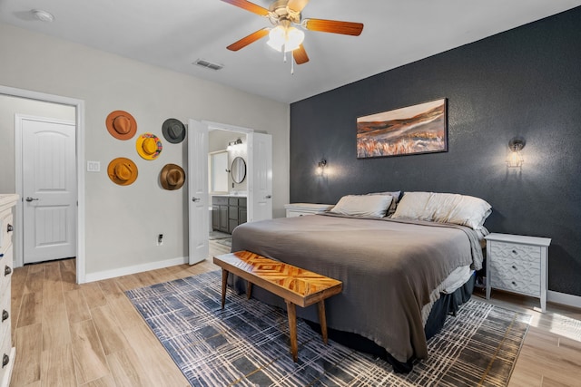 15712 Oak Pointe Dr, Fort Worth, TX 76177 - bedroom with light wood finished floors, an accent wall, baseboards, ensuite bath, and ceiling fan