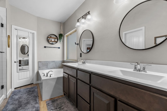 15712 Oak Pointe Dr, Fort Worth, TX 76177 - bathroom with a garden tub, double vanity, a shower stall, and wood finished floors