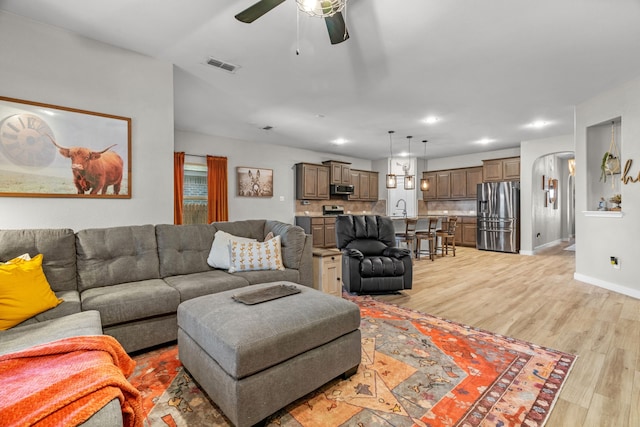 15712 Oak Pointe Dr, Fort Worth, TX 76177 - living room with light wood finished floors, a ceiling fan, recessed lighting, baseboards, and arched walkways
