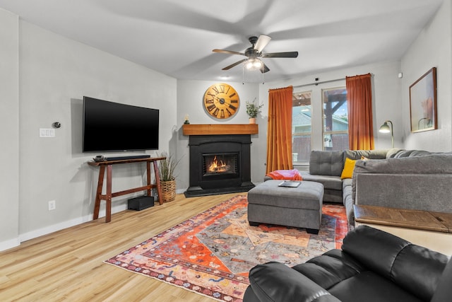 15712 Oak Pointe Dr, Fort Worth, TX 76177 - living area featuring wood finished floors, a ceiling fan, a warm lit fireplace, and baseboards