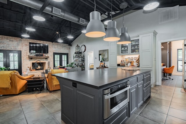 853 County Road 2215, Decatur, TX 76234 - kitchen featuring dark countertops, open floor plan, brick wall, a kitchen island, and oven
