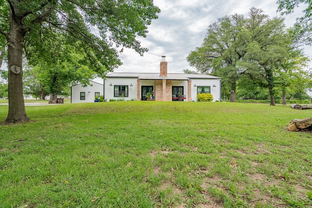853 County Road 2215, Decatur, TX 76234 - view of front facade featuring a chimney, a front yard, metal roof, and board and batten siding