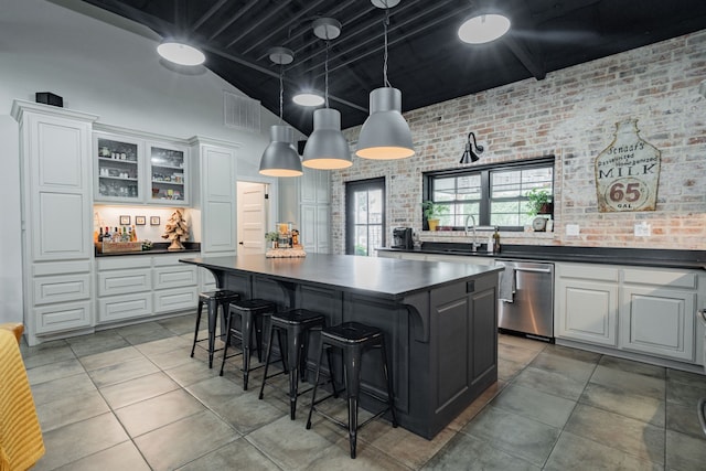 853 County Road 2215, Decatur, TX 76234 - kitchen featuring stainless steel dishwasher, dark countertops, a kitchen island, white cabinets, and a towering ceiling