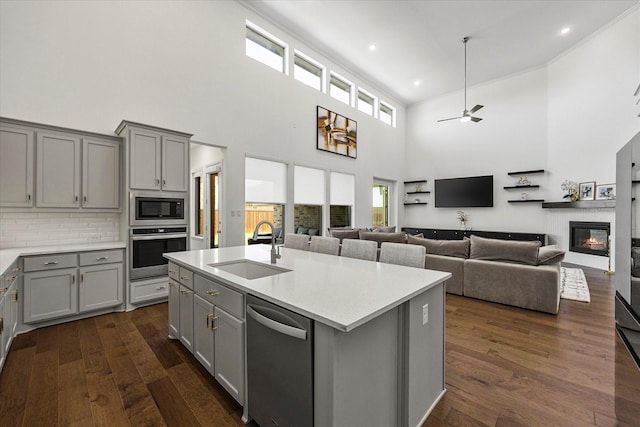 2012 Grover Ln, Rockwall, TX 75087 - kitchen featuring gray cabinetry, stainless steel appliances, a sink, a high ceiling, and a ceiling fan