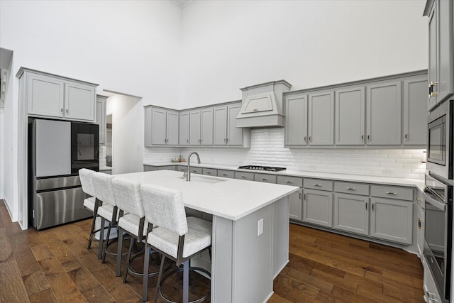 2012 Grover Ln, Rockwall, TX 75087 - kitchen featuring appliances with stainless steel finishes, gray cabinetry, a sink, custom range hood, and a high ceiling