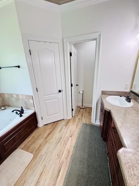 4101 Periwinkle Ln, Benton, LA 71006 - bathroom featuring vanity, a whirlpool tub, crown molding, and wood finished floors