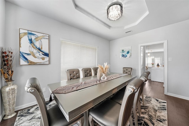 1708 Ordonez Dr, Little Elm, TX 75068 - dining room featuring a chandelier, dark wood-style floors, a tray ceiling, and baseboards