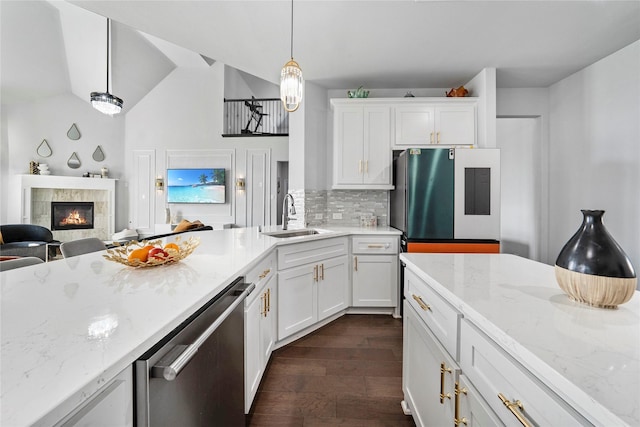 1708 Ordonez Dr, Little Elm, TX 75068 - kitchen featuring a sink, stainless steel dishwasher, freestanding refrigerator, tasteful backsplash, and a tile fireplace