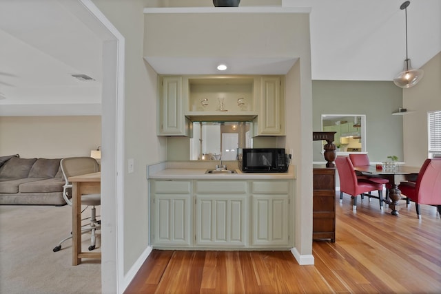 4301 Jenning Ct, Plano, TX 75093 - kitchen featuring black microwave, light countertops, light wood-style flooring, and cream cabinetry