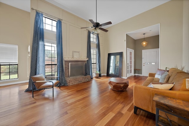 4301 Jenning Ct, Plano, TX 75093 - living area with a towering ceiling, wood finished floors, a brick fireplace, and ceiling fan