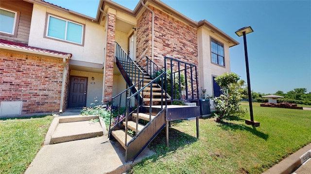 903 Turtle Lake Blvd Unit 268, Irving, TX 75060 - doorway to property featuring brick siding, a yard, stucco siding, and central AC