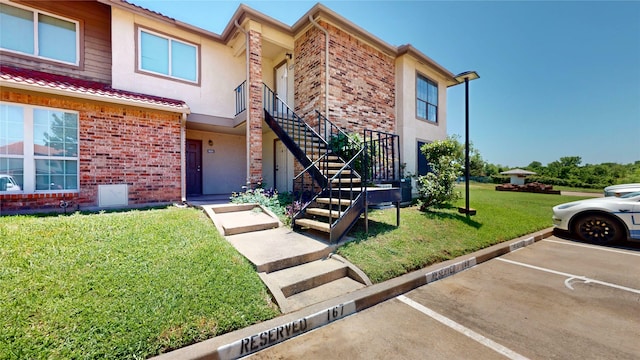 903 Turtle Lake Blvd Unit 268, Irving, TX 75060 - view of property with uncovered parking, stairway, a front yard, brick siding, and stucco siding