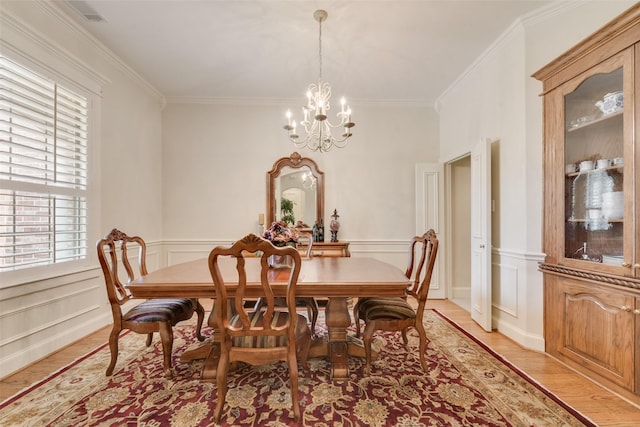 808 Country Club Dr, Heath, TX 75032 - dining area featuring a chandelier, ornamental molding, light wood finished floors, a wainscoted wall, and a decorative wall