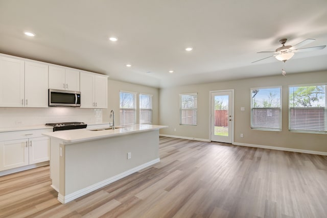 944 Linden Ct, Lavon, TX 75166 - kitchen featuring appliances with stainless steel finishes, a sink, light wood finished floors, healthy amount of natural light, and recessed lighting