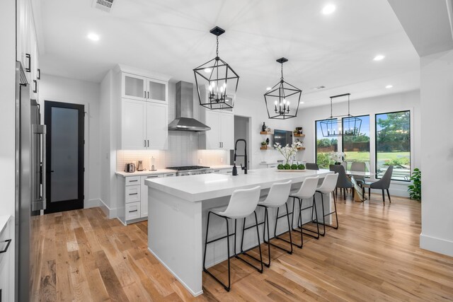 4940 Golden Bell Ln, Midlothian, TX 76065 - kitchen featuring wall chimney range hood, a kitchen breakfast bar, recessed lighting, light countertops, and tasteful backsplash