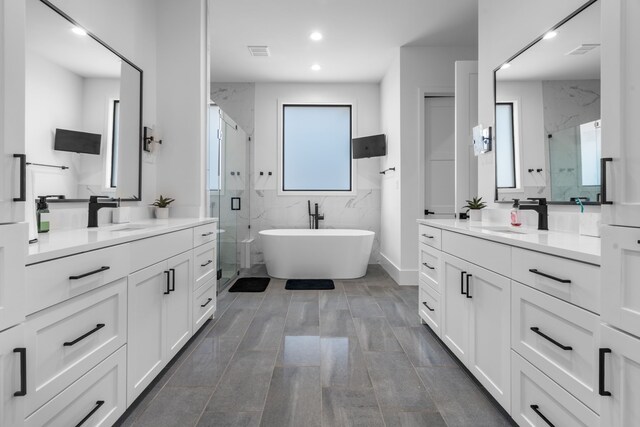 4940 Golden Bell Ln, Midlothian, TX 76065 - bathroom featuring a marble finish shower, two vanities, a freestanding tub, and recessed lighting
