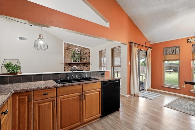 7934 Bonnie Cir, Abilene, TX 79606 - kitchen with black dishwasher, vaulted ceiling, a sink, light wood-style flooring, and brown cabinets