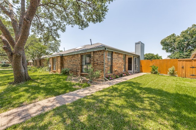 14815 Surveyor Blvd, Addison, TX 75001 - view of home's exterior featuring a chimney, brick siding, and a gate