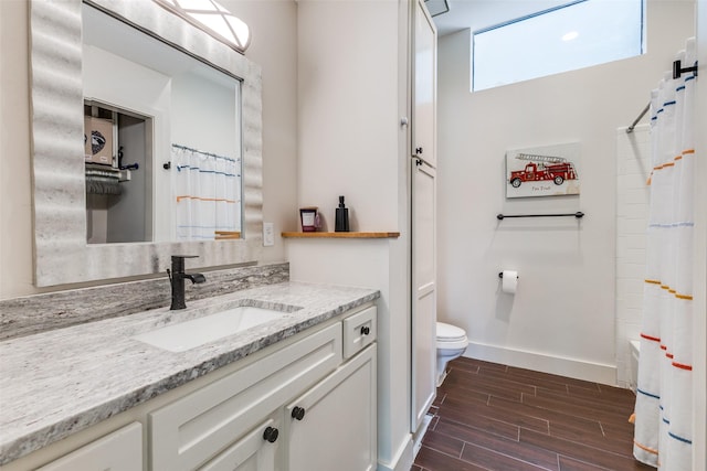 14815 Surveyor Blvd, Addison, TX 75001 - full bath with baseboards, vanity, wood finished floors, and toilet