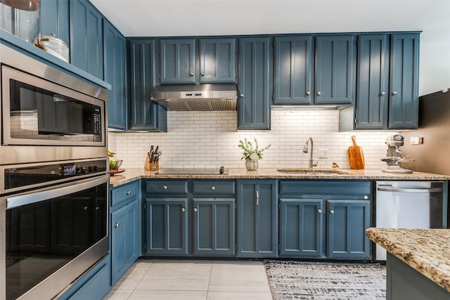 14815 Surveyor Blvd, Addison, TX 75001 - kitchen with appliances with stainless steel finishes, a sink, under cabinet range hood, blue cabinets, and backsplash