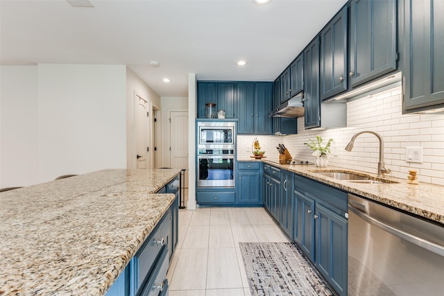 14815 Surveyor Blvd, Addison, TX 75001 - kitchen with appliances with stainless steel finishes, a sink, under cabinet range hood, blue cabinetry, and tasteful backsplash