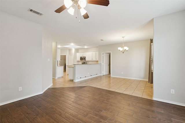 13100 Larks View Pt, Fort Worth, TX 76244 - unfurnished living room featuring a chandelier, a ceiling fan, light wood finished floors, and baseboards