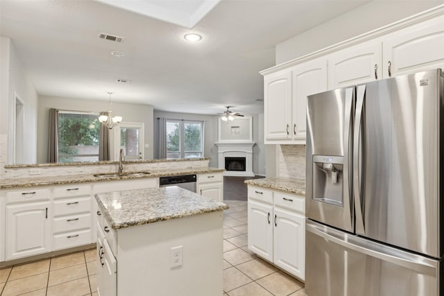13100 Larks View Pt, Fort Worth, TX 76244 - kitchen featuring appliances with stainless steel finishes, a sink, light tile patterned flooring, a ceiling fan, and a chandelier