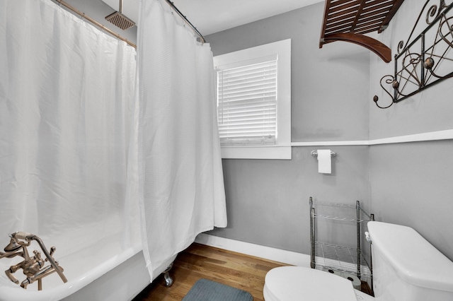 306 W Ross St, Waxahachie, TX 75165 - bathroom with toilet, wood finished floors, baseboards, and shower / bathtub combination with curtain